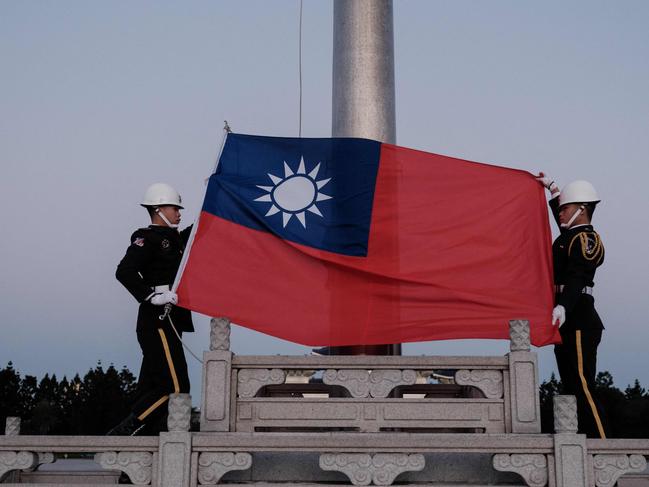 Guards raise Taiwan's national flag on the Democracy Boulevard at the Chiang Kai-shek Memorial Hall in Taipei on January 14, 2024. (Photo by Yasuyoshi CHIBA / AFP)