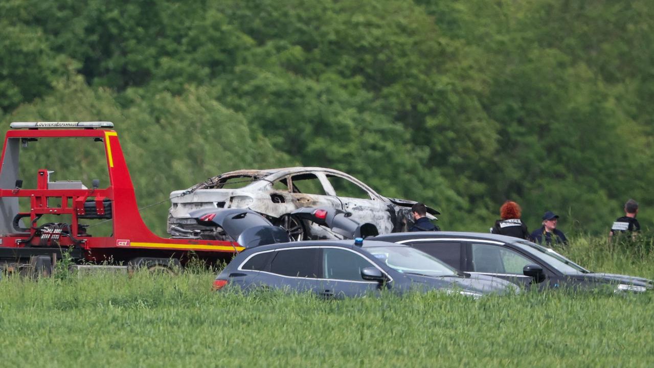 Police officers load of a burnt-out escape car that had been used during the ramming attack. Picture: Alain Jocard/AFP