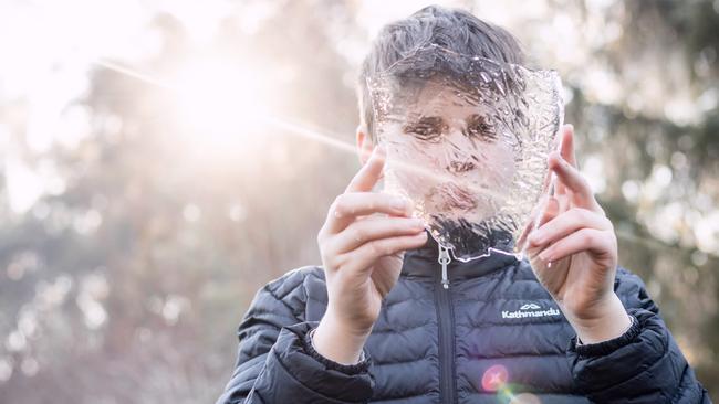 Chase Abbott, 14, holds up a frozen puddle in the Huon Valley, south of Hobart, this morning. Picture: MISSY ABBOTT