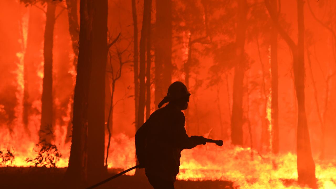 RFS volunteers and NSW Fire and Rescue officers protect a home near Gospers Mountain north west of Sydney last month. Picture: Dean Lewins/AAP