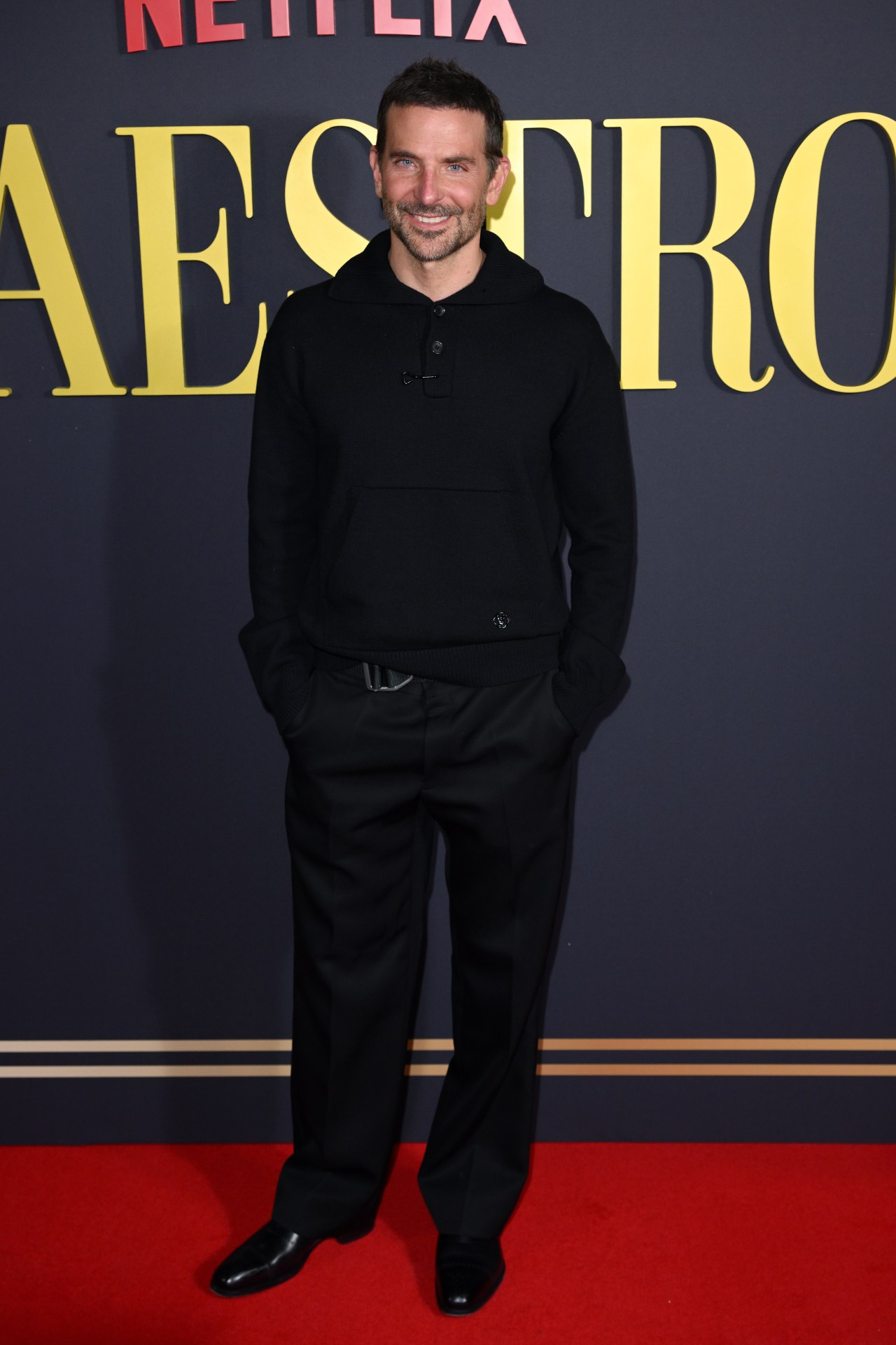 <p>Swapping his traditional red carpet uniform for something a little more laid-back, here Cooper opts for a luxe collared polo. Breaking up his all-black ensemble is a utilitarian belt buckle, just in case.&nbsp;</p>