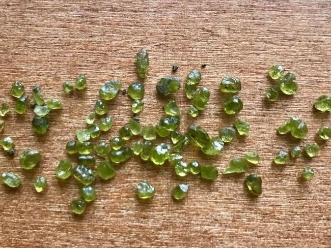 Tiny green gems, known as olivine, are being discovered in Hawaii in the areas most impacted by the volcano's lava flows. Picture: Twitter/Erin Jordan