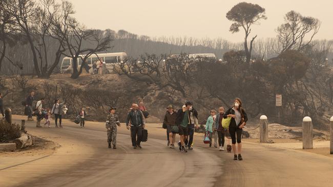 Evacuess walk down to the beach at Mallacoota to board vessels and be ferried out to HMAS Choules. Picture: ADF