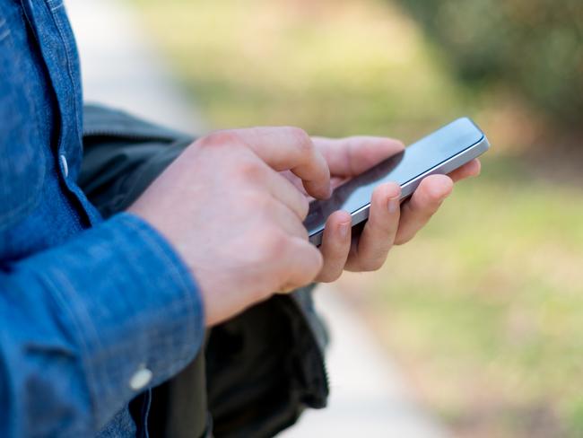 Male hands typing on smartphone.