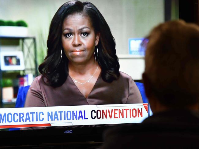 A person watches former First Lady Michelle Obama speak during the opening night of the Democratic National Convention, being held virtually amid the novel coronavirus pandemic, in Los Angeles, on August 17, 2020. - America's political convention season begins tonight with former first lady Michelle Obama addressing the Democrats' now-virtual gathering set to anoint Joe Biden, as President Donald Trump defies coronavirus concerns to rally supporters in battleground Wisconsin. (Photo by Chris Delmas / AFP)