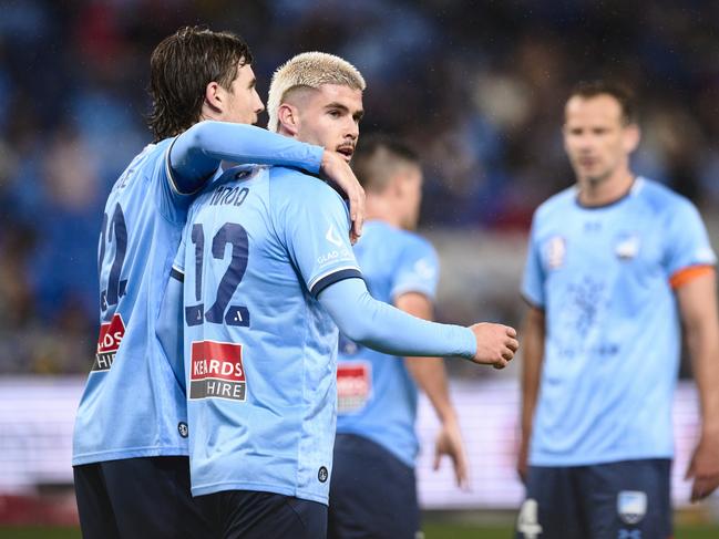 Patrick Wood (12) is congratulated by Sydney FC teammate Max Burgess after scoring against Newcastle. Picture: Brett Hemmings/Getty Images