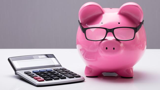 Close-up Of A Piggybank With Eyeglasses And Calculator On Desk; investing superannuation money calculations generic