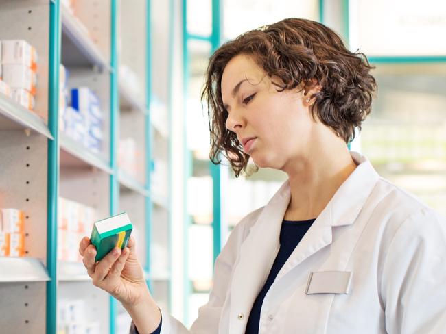 Generic photo of a pharmacist taking medicine from shelf at a  pharmacy. Picture: iStock