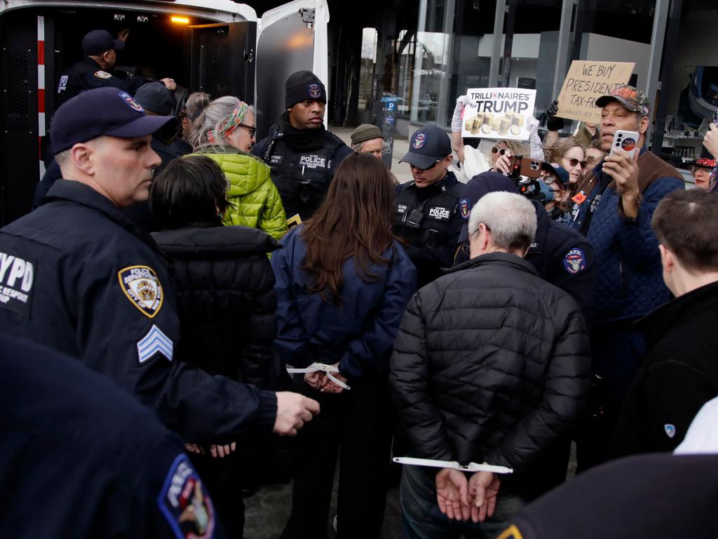 A man is arrested during a "TeslaTakedown" protest against Elon Musk outside of a Tesla dealership in New York, March 1, 2025. (Photo by Leonardo Munoz / AFP)