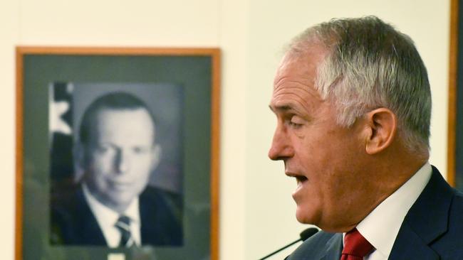 Prime Minister Malcolm Turnbull with a portrait of former prime minister Tony Abbott during a Coalition joint partyroom meeting at Parliament House in Canberra, Tuesday, Feb. 7, 2017. (AAP Image/Mick Tsikas) NO ARCHIVING