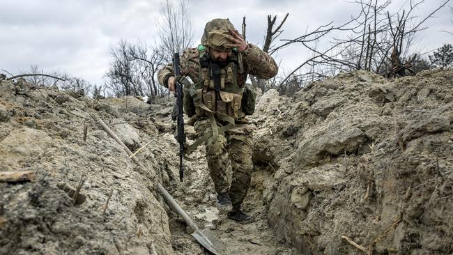 Ukrainian medic ‘Doc’ with the 28th Brigade runs through a partially dug trench along the frontline outside of Bakhmut. Picture: Getty Images