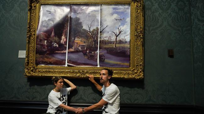 Activists glue themselves to The Hay Wain by John Constable at the National Gallery in London. Picture: Getty Images