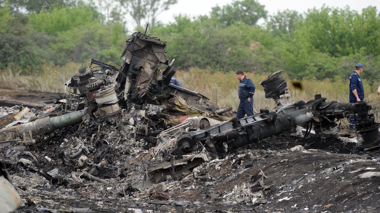 July 18, 2014. Rescuers stand on the site of the crash of a Malaysian airliner carrying 298 people from Amsterdam to Kuala Lumpur, near the town of Shaktarsk, in rebel-held east Ukraine. (Photo by DOMINIQUE FAGET / AFP)