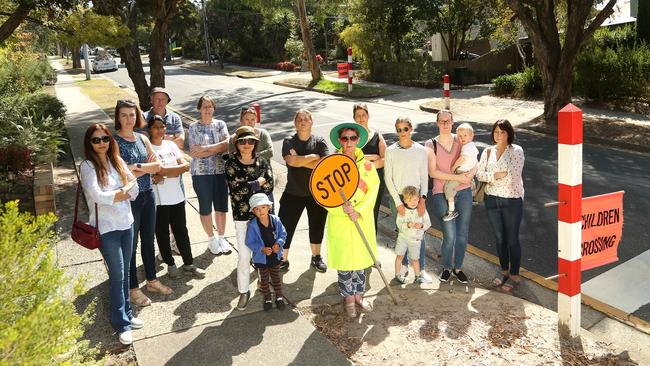 Crossing supervisor Lorron Lewis with concerned families at her crossing, which could be closed. Picture: Hamish Blair