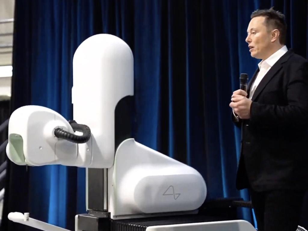 Elon Musk next to Neuralink’s surgical robot. Picture: Neuralink/AFP