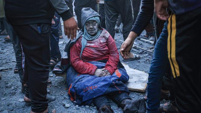 A woman injured in an Israeli strike sits amid the rubble in Rafah in the southern Gaza Strip on December 3.