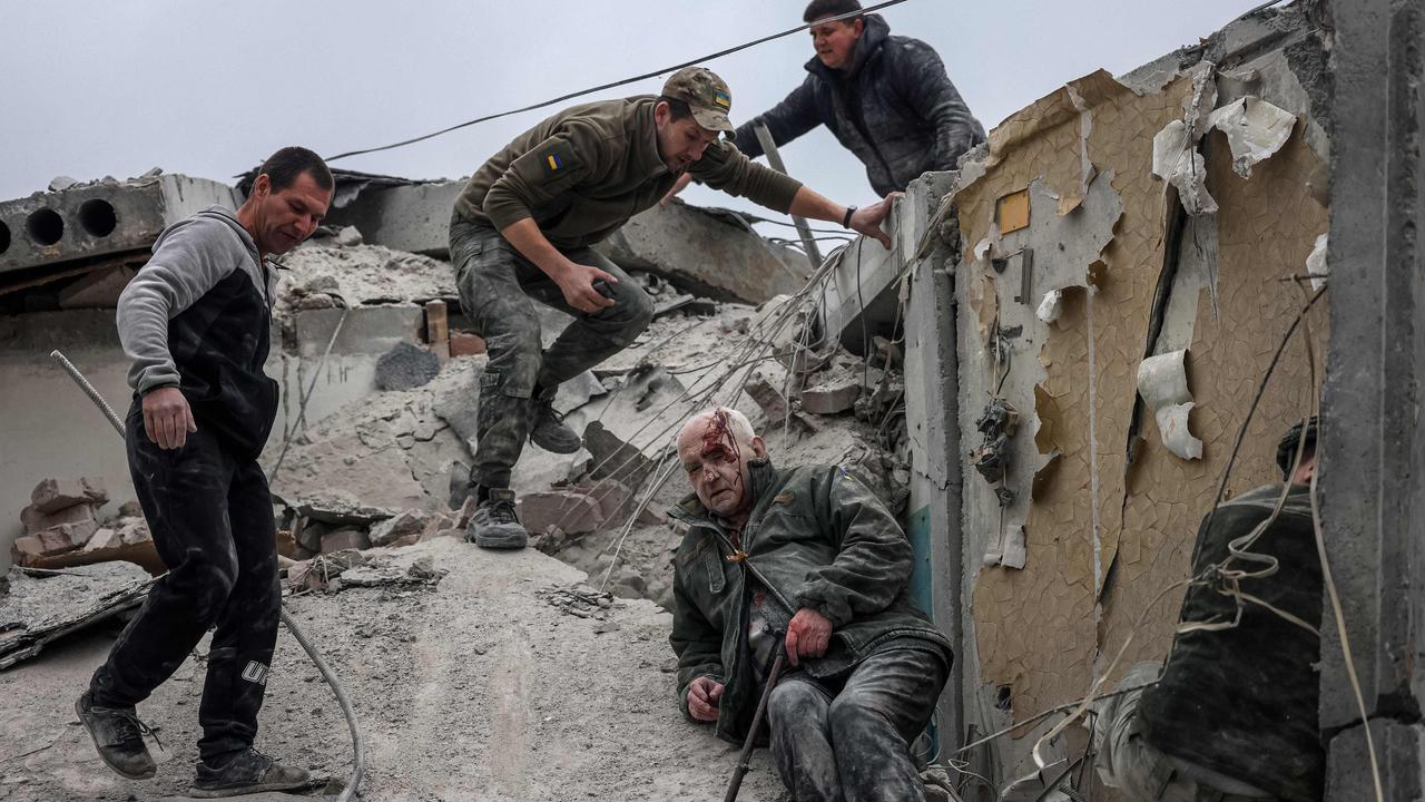 Emergency workers rescue an injured elderly man from a unit block that was shelled by Russian forces. Picture: Anatolii Stepanov/AFP