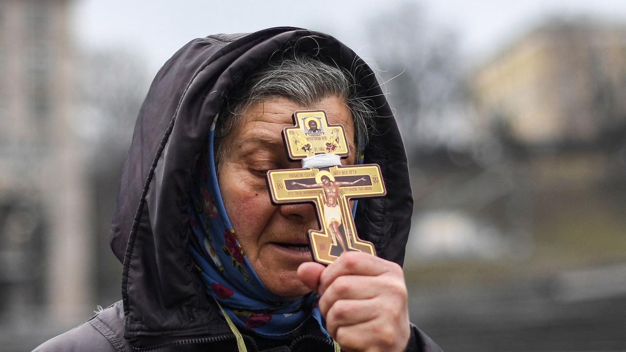 A religious woman holds a cross as she prays on Independence square in Kyiv. Picture: Daniel Leal/AFP