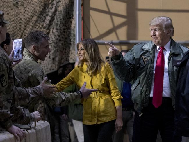 President Donald Trump and first lady Melania Trump greet members of the military as they arrive for a hanger rally at Al Asad Air Base, Iraq, Wednesday, Dec. 26, 2018. In a surprise trip to Iraq, President Donald Trump on Wednesday defended his decision to withdraw U.S. forces from Syria where they have been helping battle Islamic State militants. (AP Photo/Andrew Harnik)