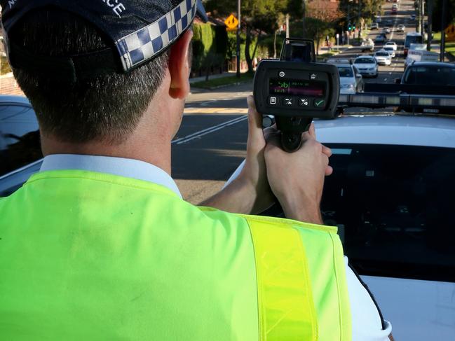 Pictured is a Highway Patrol Officer with a speed gun reading from a car that was clocked at 56kmh in a school zone at 2.52pm in Dulwich Hill.Picture: Richard Dobson