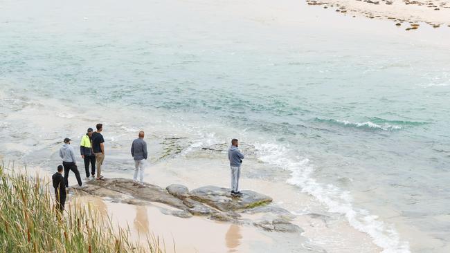 Family members scan The Entrance channel, searching for Laith. Picture: Max Mason-Hubers