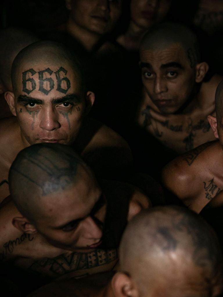 An inmate shows off a “666” face tattoo.