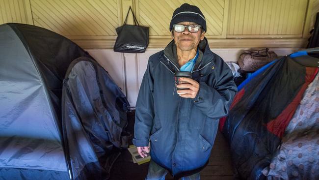 Squatter Dinh stands next to his tent in the Brunswick St Oval grandstand. Picture: Jake Nowakowski