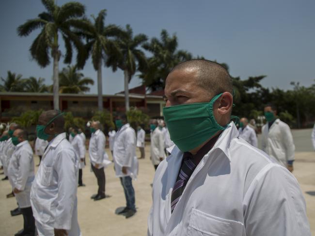 Cuban doctors form up during a farewell ceremony as they get ready to leave for Italy to help with the new coronavirus pandemic, in Havana, Cuba. Picture: AP