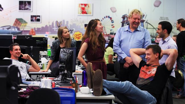 WiseTech Global's Richard White (blue shirt) with workers (from left-Right) Nataliia Mishchenko, Miranda Letford, Igor Nuhnov (seated) and Christos Moustakas .  The employment contract of workers at  WiseTech Global requires employees to meet with their manager if they work more than 40 hours a week regularly. Photographed at their workplace headquarters in Alexandria, Sydney. Pic - Sam Mooy