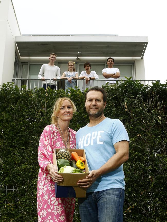 L to R: Diane and Paul Harapin in front of their home with a box of produce with children Tyler Harapin -18, Kaiya Harapin -12, Edyn Harapin -15 and Nathan Harapin -21 on the Balcony. Picture: John Appleyard