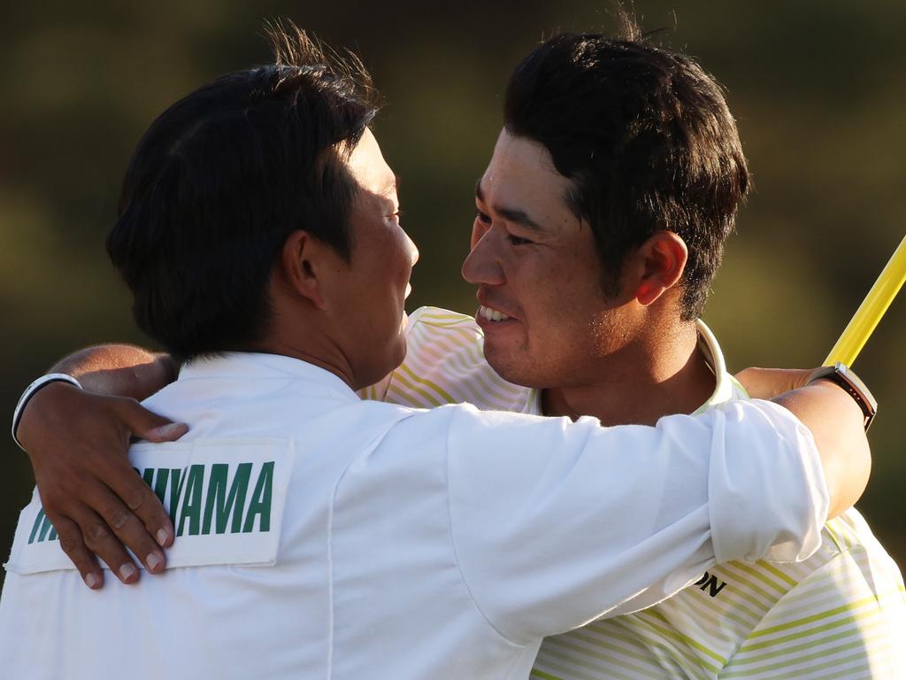 Hideki Matsuyama of Japan hugs his caddie, Shota Hayafuji. Getty.