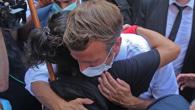 A Lebanese youth hugs French President Emmanuel Macron during a visit to the Gemmayzeh neighbourhood, which suffered extensive damage in the explosion in the Lebanese capital. Picture: AFP.