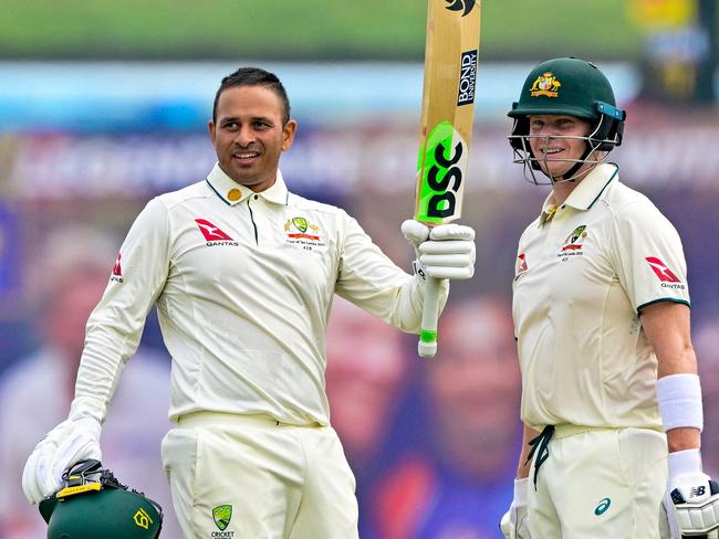 Australia's Usman Khawaja (L) celebrates with captain Steve Smith after scoring a century (100 runs) during the first day of the first Test cricket match between Sri Lanka and Australia at the Galle International Cricket Stadium in Galle on January 29, 2025. (Photo by Ishara S. KODIKARA / AFP)