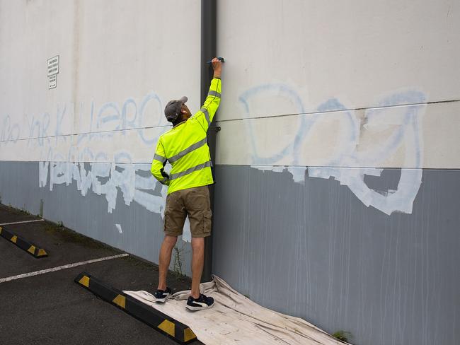 A council worker removes graffiti on the wall of the carpark at the Mount Sinai College in Maroubra. Picture: NewsWire / Gaye Gerard