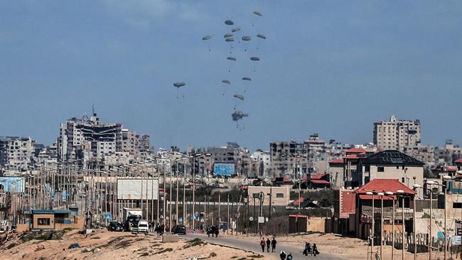 Parachutes attached to parcels of humanitarian aid are airdropped over Gaza City. Picture: AFP