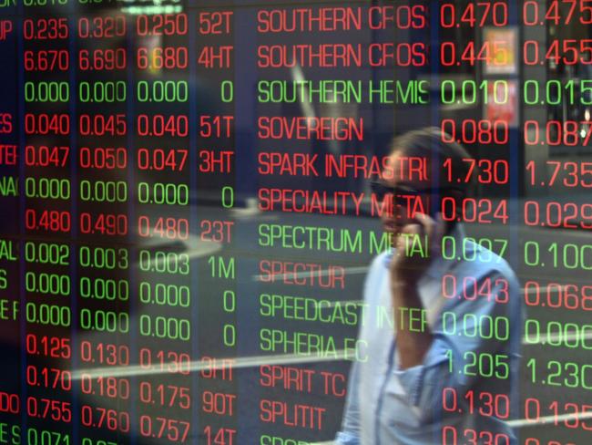 A pedestrian is reflected in the window of the Australian Securites Exchange in Sydney on March 13, 2020, as Australian stocks were down 7.3 percent in early trading. - Global stock markets suffered historic falls as panic spread on March 13 over the spiralling coronavirus crisis that has killed nearly 5,000 and infected sport, schools and society across the planet. (Photo by Saeed KHAN / AFP)