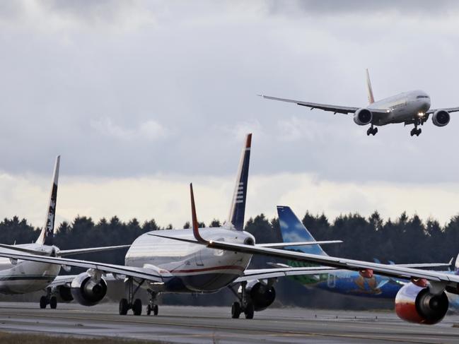 One passenger jet comes in for a landing and in view of a line of planes waiting to takeoff, Wednesday, Dec. 16, 2015, at Seattle-Tacoma International Airport, in SeaTac, Wash. Boeing Co., Alaska Airlines and the Port of Seattle announced Wednesday that they are partnering on a $250,000 study to explore how to bring more aviation biofuel to airplanes at Seattle-Tacoma International Airport. Executives for the companies and port signed an agreement, saying the study will help stimulate production of alternatives to conventional jet fuel. They say the longer term plan is to incorporate more biofuel into the airport’s fuel farm, which is used by all 26 airlines. (AP Photo/Elaine Thompson)