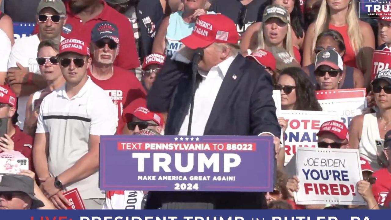 Trump grabs his ear as a bullet whizzes past his head. Picture: Getty Images