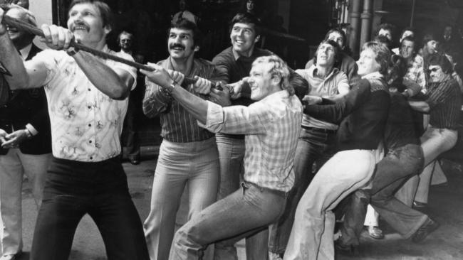 Premiership players from Port Adelaide pull on the rope to unveil their team colours painted on the West End Brewery chimney in 1977.