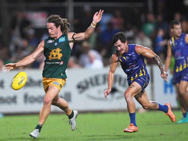 St.Mary's Jackson Geary mid kick as Wanderers Simon Gates chases him down during Saturday's NTFL Premier League Grand Final.