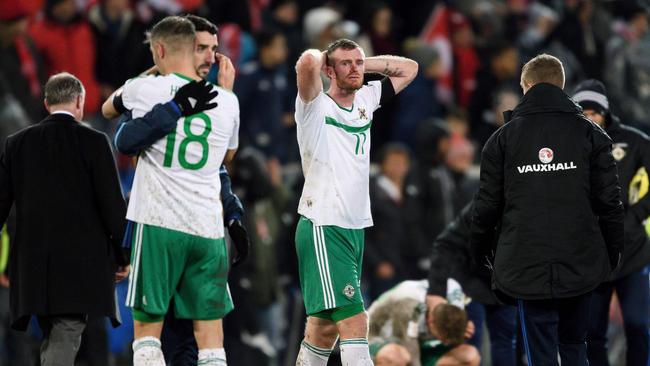 Northern Ireland's defender Aaron Hughes (L) and teammates midfielder Chris Brunt (C) react.