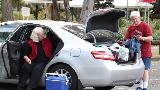 The couple and the car they have been calling home while they hunt for a rental. Picture: Glenn Hampson