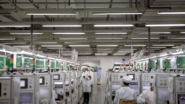 Foxconn employees work along a production line in the Longhua Science and Technology Park, also known as Foxconn City, in Shenzhen, China.