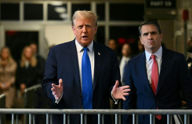 Former president Donald Trump speaks to reporters before entering court for the first ever criminal trial of a former president