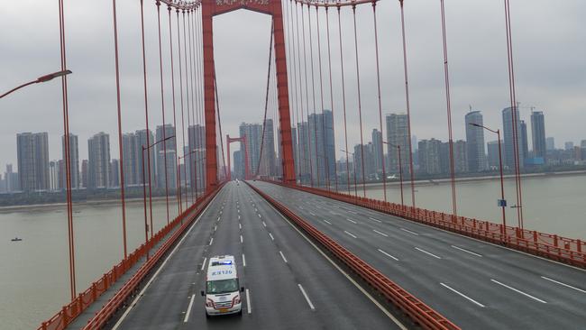 An ambulance drives across a nearly empty bridge in the central Chinese city of Wuhan, where the coronavirus has hit hardest. Picture: AP