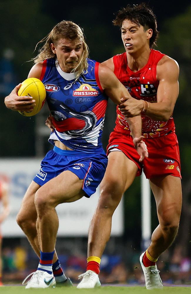 Bailey Smith of the Bulldogs is tackled by Alex Davies of the Suns during the 2023 AFL Round 11 match between the Gold Coast Suns and the Western Bulldogs at TIO Stadium. (Photo by Michael Willson/AFL Photos via Getty Images)