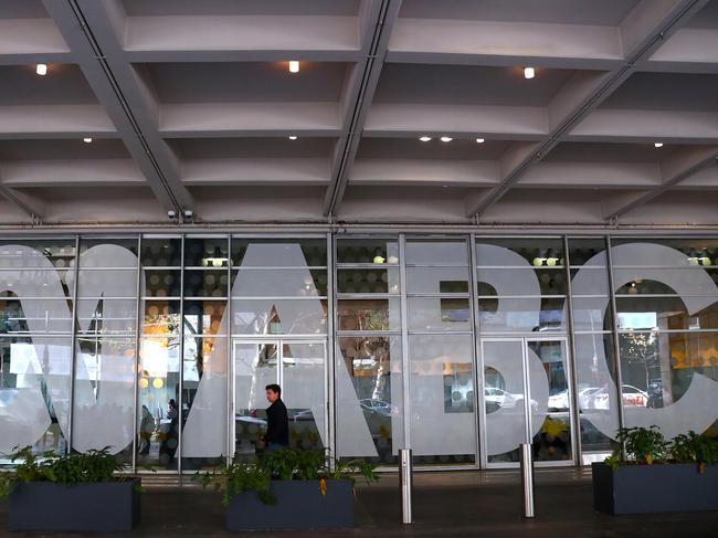 An employee walks past the logo of the ABC located at the main entrance to the ABC building located at Ultimo in Sydney, Wednesday, June 5, 2019. Federal police officers have raided ABC's Sydney offices over stories published in 2017 that suggested Australian troops may have committed war crimes. (AAP Image/David Gray) NO ARCHIVING