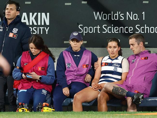 Bryde O'Rourke is seen on the bench with Geelong staff. Picture: Michael Willson/AFL Photos via Getty Images