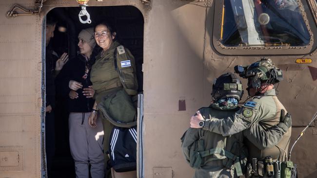 Israeli helicopter crew members embrace as Daniella Gilboa waits to leave the helicopter after arriving at hospital on Saturday. Picture: Chris McGrath/Getty Images