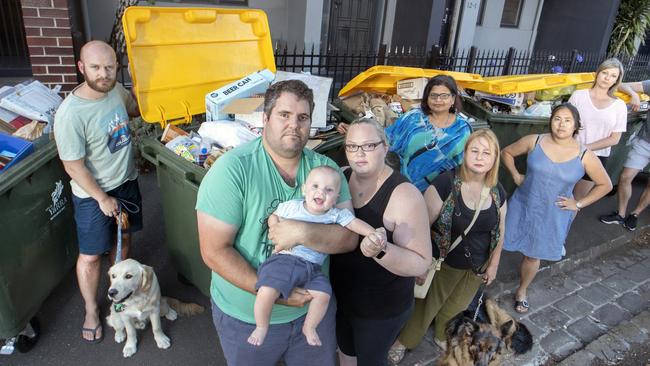 Adam and Kathleen Promnitz (front) with eight-month-old son Xavier and residents in Abbotsford are upset about overflowing bins. Picture: David Geraghty